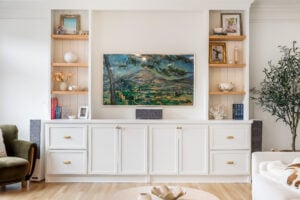 Living room built-in cabinetry with mounted TV and natural wood shelves